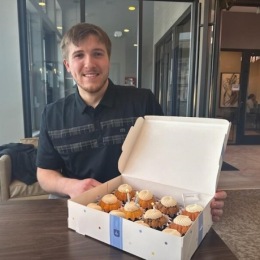 Live at the 450 Man sitting with box of cupcakes